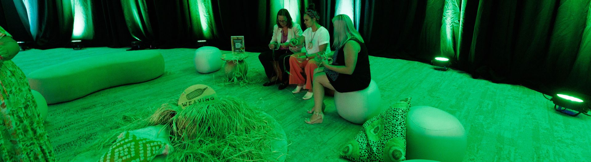 Delegates participating in a Yarning Circle at RESPECT: An ICC Sydney Experience, in a calming green filled room.