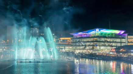 ICC Sydney's Convention Centre exterior image including a blue light projected onto a water feature.