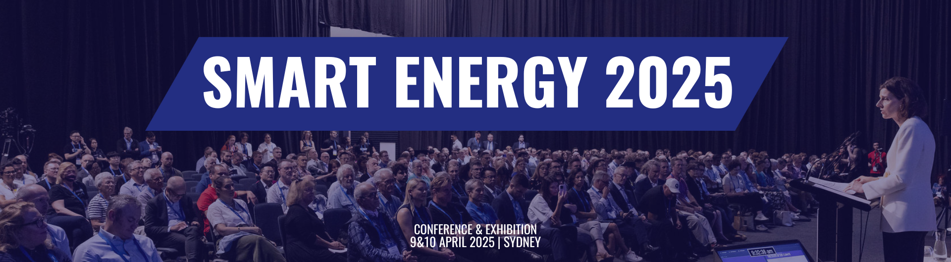 Smart Energy conference and exhibition promo at ICC Sydney, 9 to 10 of April. Image of a woman behind a lecturn speaking to a crowd.