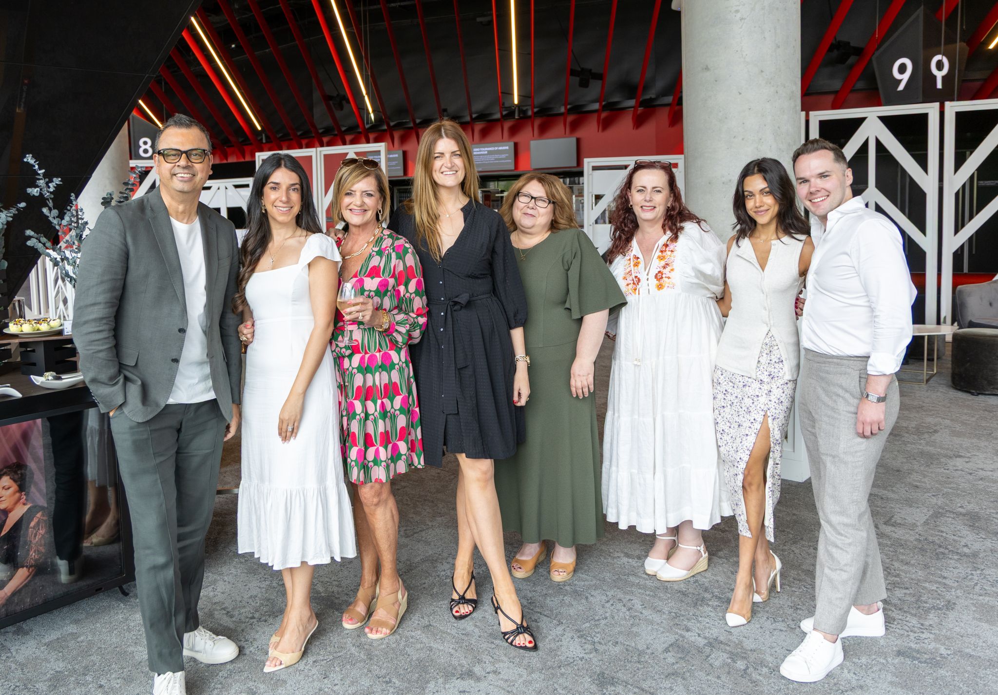 ICC Sydney team and charity partners smiling at the camera at level 4 AMEX lounge