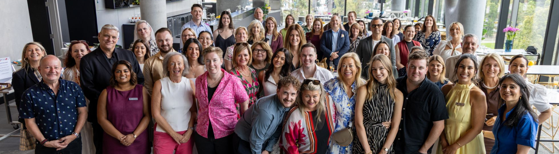 ICC Sydney team and charity partners smiling at the camera at level 4 AMEX lounge